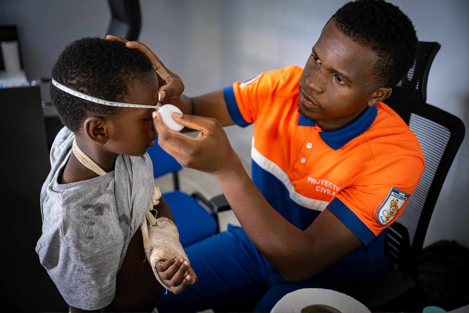 Un soignant de la Protection Civile Santé Mayotte mesure le tour de tête d'un jeune garçon pendant une consultation.