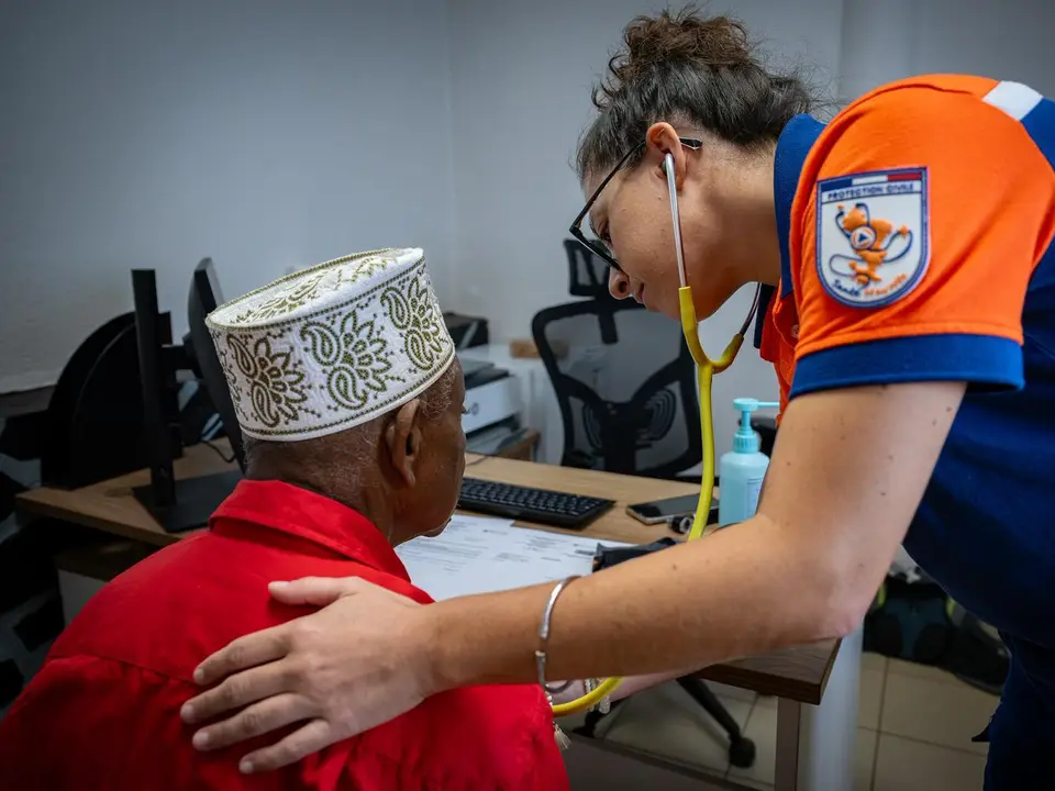 Une soignante de la Protection Civile Santé Mayotte ausculte un patient au stéthoscope.